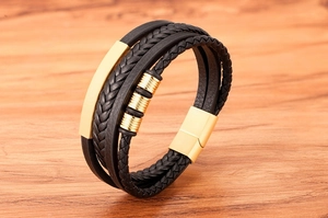 Detail of multi-layer braided leather bracelet with gold metal bars and magnetic clasp