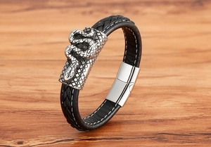 Detail eines geflochtenen Lederarmbands mit silberner Schlange und Magnetverschluss