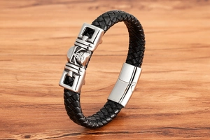 Close-up of men's punk leather bracelet with silver skull charm and magnetic clasp