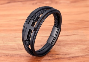 Detail van meerlaagse zwarte lederen armband met matte kruis en magnetische sluiting
