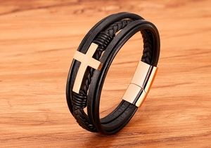 Detail van meerlaagse zwarte lederen armband met roségouden kruis en magnetische sluiting