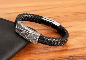 Close-up of men's braided leather bracelet with Masonic square and compass steel clasp