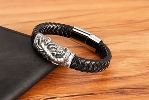 Detail of men's black braided bracelet featuring a silver metal scorpion and magnetic clasp