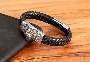 Detail of men's braided leather bracelet featuring a silver owl charm and magnetic clasp