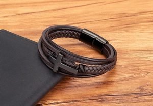 Gedetailleerd macrozicht van de meerlaagse herenarmband van bruin leer met kruis