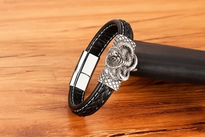 Detailansicht des schwarzen Lederarmbands mit silbernem Kobrakopf und Magnetverschluss für Herren
