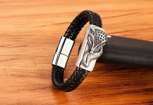 Detail of black braided leather bracelet featuring a silver fox head and magnetic clasp