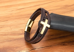 Detail van de meerlaagse bruine leren armband met gouden kruis en magnetische metalen sluiting