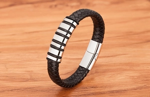 Close-up of black braided leather men's bracelet with polished stainless steel rings