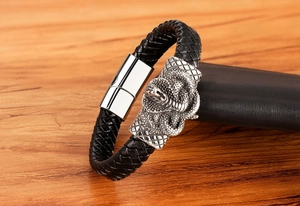 Close-up of men's black woven leather bracelet with silver snake-engraved metal magnetic clasp