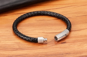Détail d'un bracelet en cuir tressé noir avec fermoir magnétique en acier texturé