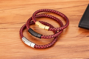 Detailed view of woven burgundy leather bracelets with gold, black, and silver clasps