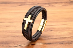 Detail van klassieke lederen kruisarmband met gouden magneetsluiting op houtoppervlak