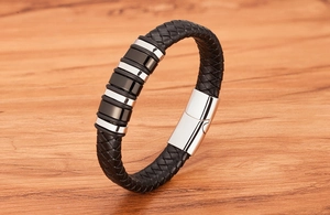 Detail of black braided leather men's bracelet with stainless steel rings and magnetic clasp