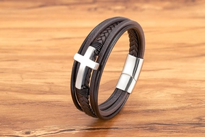 Detail van meerlaagse bruine leren herenarmband met zilveren kruis en magnetische sluiting