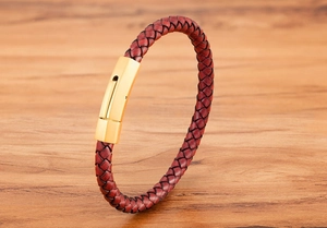 Close-up of braided burgundy leather bracelet with polished gold stainless steel clasp