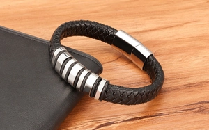 Detail of woven black leather men's bracelet with five polished stainless steel rings