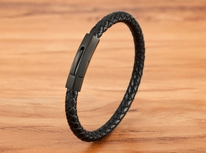 Close-up of black braided leather texture and matte black stainless steel magnetic clasp