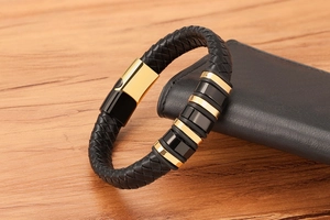 Detailed close-up of a black woven leather men's bracelet with gold magnetic buckle