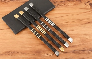 Detail of woven black leather men's bracelets with metallic accents and magnetic clasps