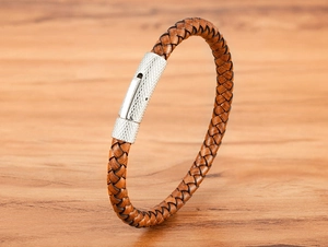 Détail d'un bracelet en cuir tressé marron avec fermoir métallique argenté texturé