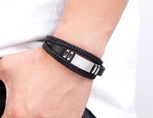 Detail eines mehrlagigen geflochtenen Lederarmbands mit polierten Edelstahlelementen