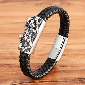 Men's black braided leather bracelet featuring a silver skull relief and magnetic clasp