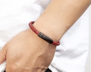 Close-up of red braided leather bracelet with black matte magnetic clasp on a wrist