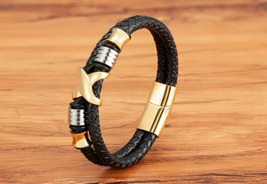 Makroaufnahme von Herren Lederarmband mit goldenem Vogelanhänger und Magnetverschluss
