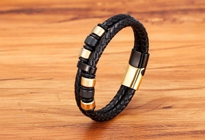 Detail von geflochtenem schwarzem Lederarmband mit Magnetverschluss und Metallperlen