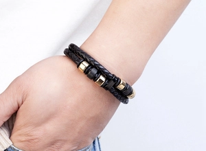 Nahaufnahme eines zweilagigen Lederarmbands für Herren mit goldenen und strukturierten Perlen