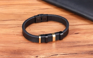 Dettaglio del bracciale da uomo in pelle nera con anelli in acciaio e chiusura a clip