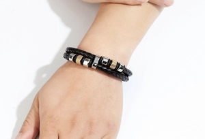 Nahaufnahme von geflochtenem Lederarmband für Herren mit gold- und silbernen Metallperlen