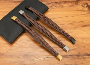 Vue macro détaillée de bracelets en cuir tressé multicouche avec fermoirs or, argent et noirs