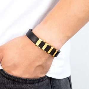 Bracciale da uomo in pelle litchi nera con quattro inserti in oro indossato al polso