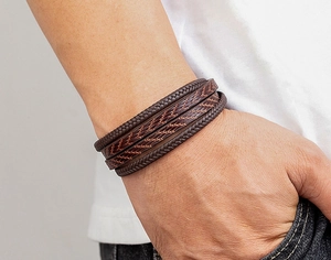 Gros plan du bracelet multicouche pour homme en cuir tressé avec détails texturés