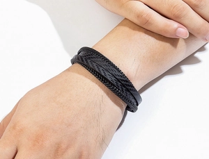 Détail d'un bracelet multi-rangs en cuir tressé pour homme avec texture carbone