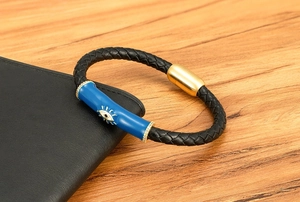 Detalle del colgante de ojo turco en pulsera de cuero trenzado con cierre magnético dorado