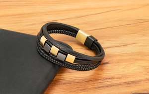 Detail eines mehrlagigen Lederarmbands mit gold-schwarzen Metallblöcken und Magnetverschluss