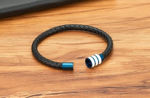 Détail du bracelet en cuir tressé noir pour homme avec fermoir magnétique bleu et rayure