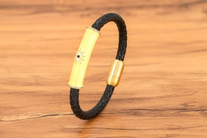 Detalle de pulsera de cuero con amuleto de ojo turco esmaltado y cierre magnético dorado