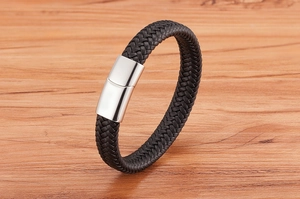 Détail d'un bracelet pour homme en cuir tressé noir avec fermoir magnétique en argent poli