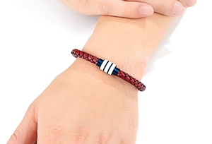 Macro-opname van de rode leren gevlochten herenarmband met gestreepte metalen sluiting