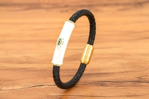 Detalle de pulsera de cuero para hombre con amuleto de ojo de diablo y cierre magnético