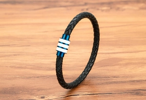 Détail macro du bracelet en cuir tressé pour homme avec fermoir magnétique à rayures bleues