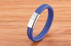 Détail d'un bracelet en cuir tressé bleu avec un fermoir magnétique en argent poli