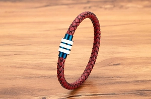 Macro-opname van een herenarmband van rood gevlochten leer met een blauwe magnetische sluiting