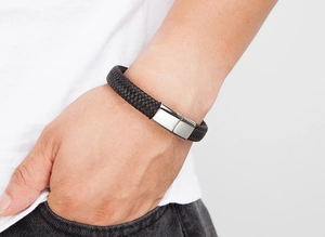 Gros plan d'un bracelet tressé en cuir pour homme avec fermoir magnétique poli au poignet