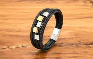 Nahaufnahme der mehrlagigen Lederarmbänder mit Magnetverschluss auf Holzhintergrund