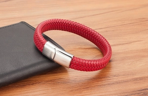 Vue macro d'un bracelet tressé rouge avec fermoir magnétique en métal argenté brossé